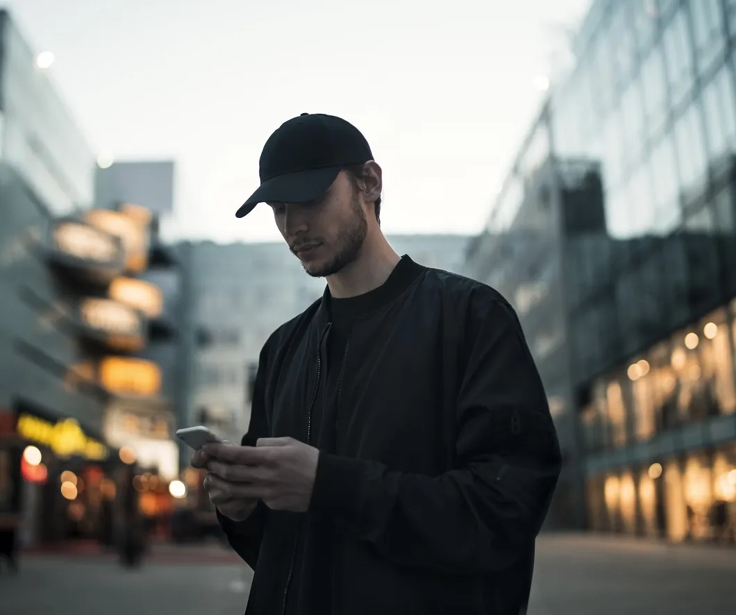 Guy in cap holding his phone